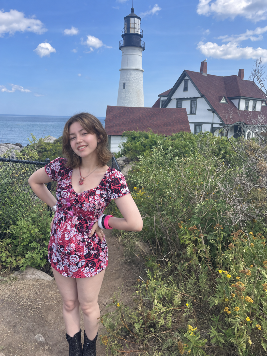 Leah beside a coastal lighthouse